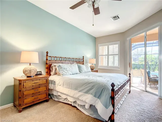 Carpeted bedroom with a ceiling fan and ensuite bath