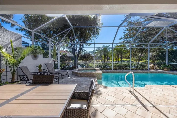 View of swimming pool with a lanai, an in ground hot tub, and a patio