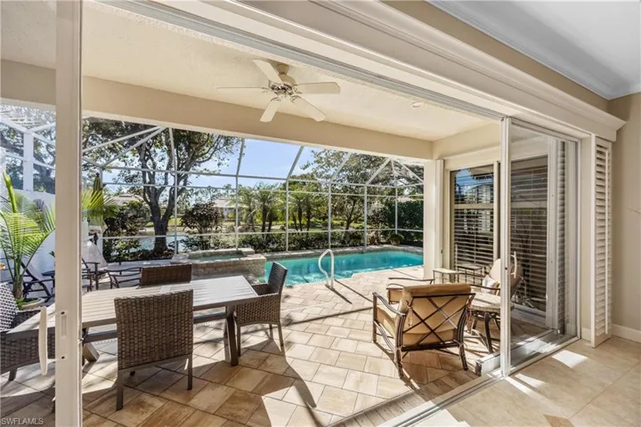 View of swimming pool with ceiling fan, a lanai, and a patio