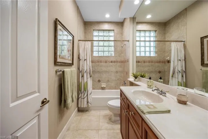 Full bathroom with tile patterned flooring, vanity, shower / bath combo, and toilet