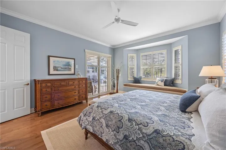 Bedroom with wood-type flooring, ceiling fan, and ornamental molding