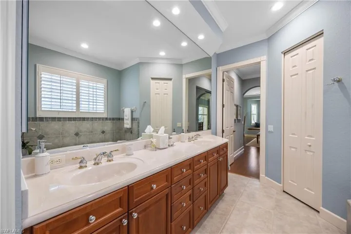 Bathroom featuring tile patterned floors, vanity, and ornamental molding