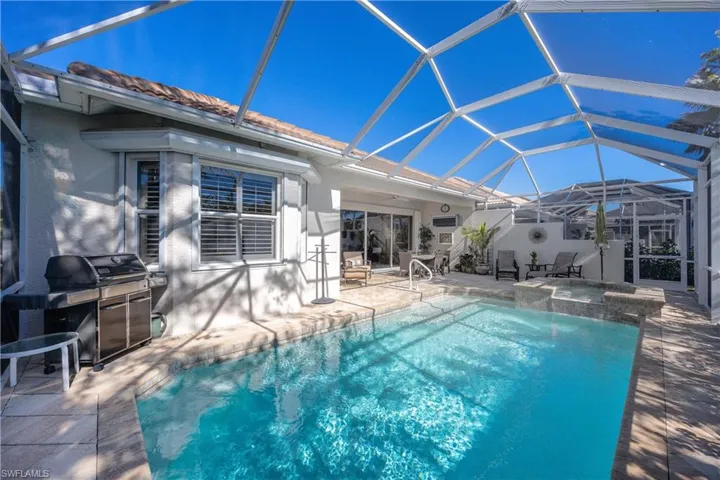 View of swimming pool with area for grilling, a lanai, and a patio area