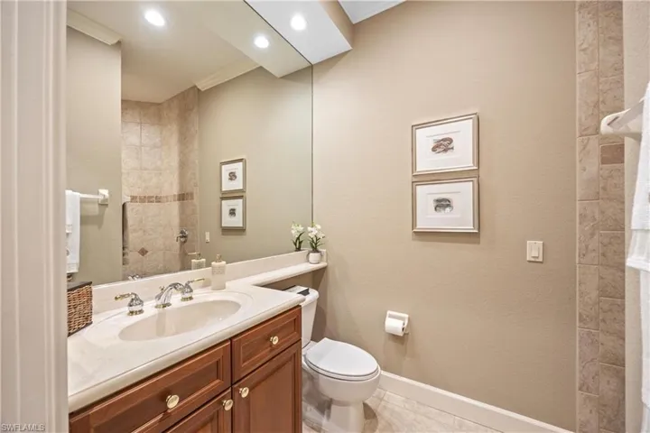 Bathroom with tile patterned flooring, vanity, toilet, and crown molding