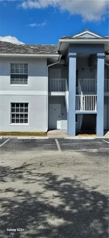 View of front of house featuring a balcony, stucco siding, and a shingled roof