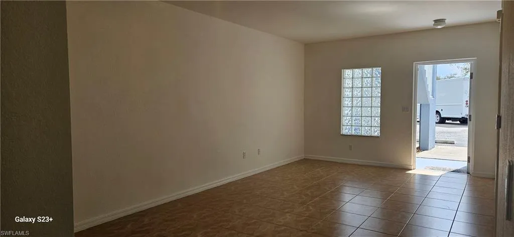 Tiled empty room featuring baseboards