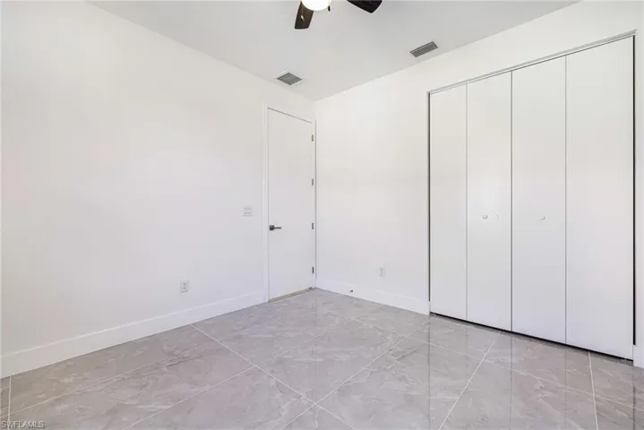 Unfurnished bedroom featuring a ceiling fan and a closet