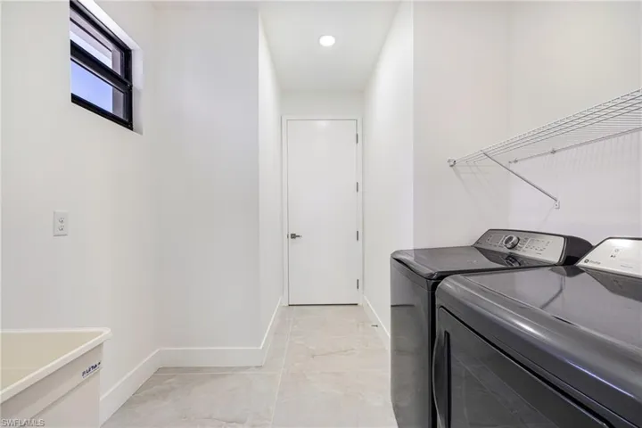 Washroom featuring baseboards and washer and clothes dryer