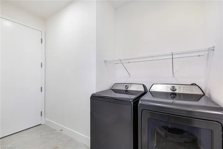 Laundry room featuring baseboards and washing machine and clothes dryer