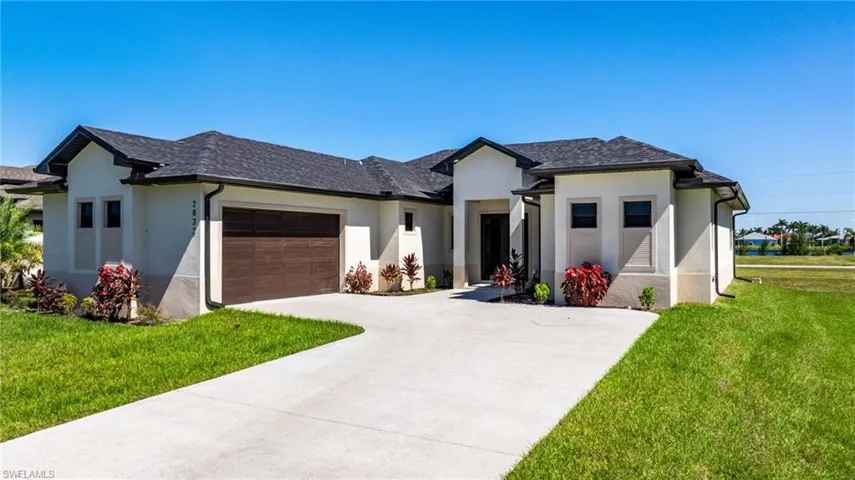 Prairie-style home with a front lawn, stucco siding, and an attached garage