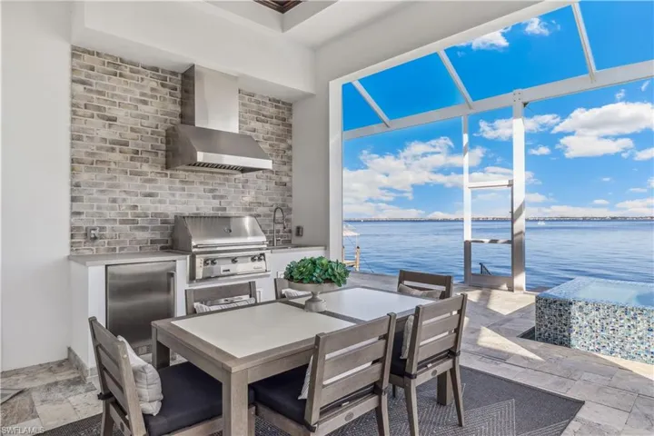 View of patio / terrace with a grill, sink, a water view, and exterior kitchen
