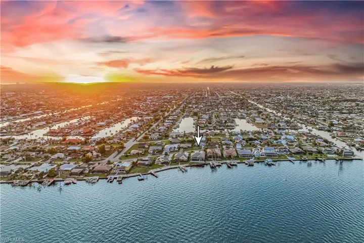 Aerial view at dusk featuring a water view
