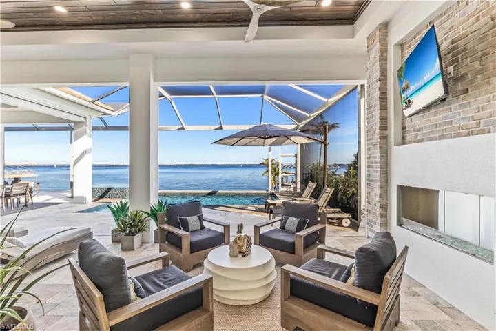 View of patio featuring outdoor lounge area, a water view, ceiling fan, and a lanai