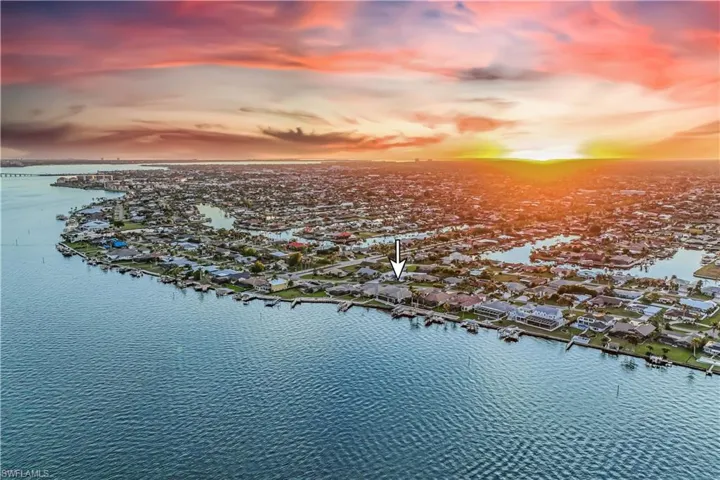 Aerial view at dusk featuring a water view