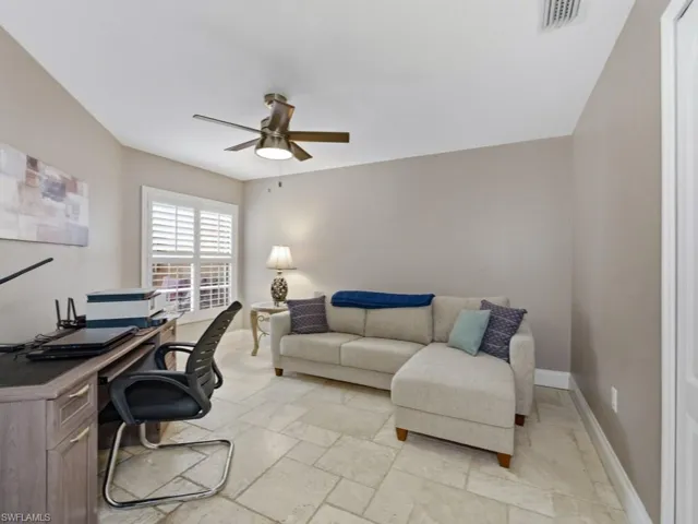 Home office with stone tile flooring and ceiling fan