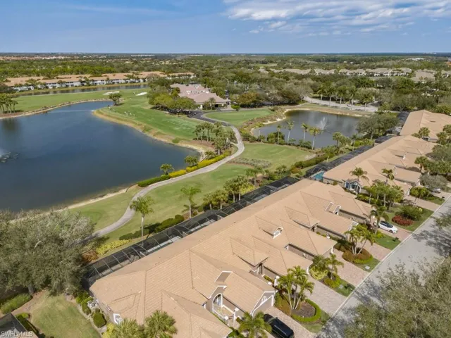 Aerial view of residential area with a nearby body of water and a golf course