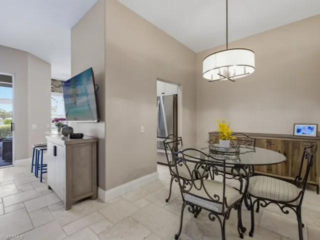 Dining room with stone tile flooring and vaulted ceiling