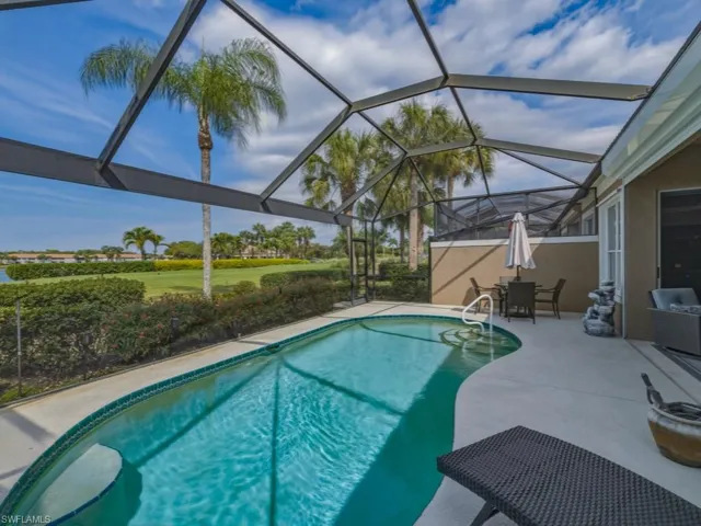 Outdoor pool with a sunroom, a patio, outdoor dining space, and glass enclosure