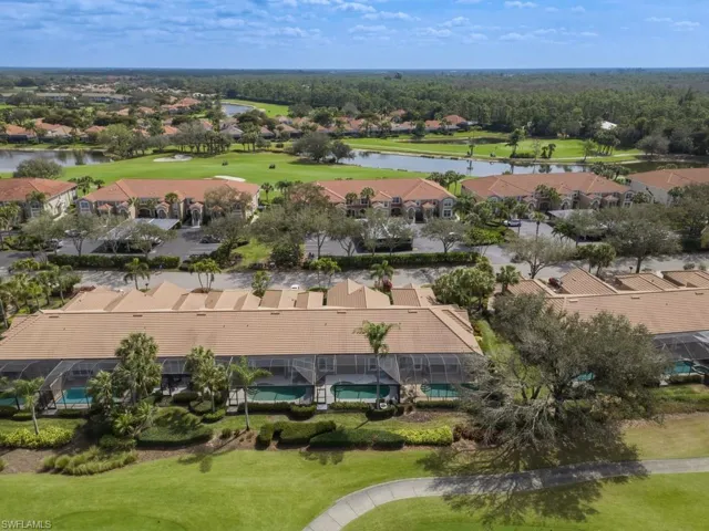 Aerial view of residential area with a golf course and a nearby body of water
