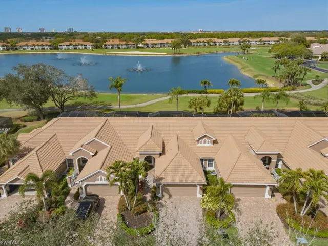 Aerial view of residential area featuring a nearby body of water and a local golf course