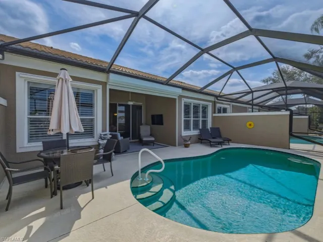Outdoor pool with a lanai, a sunroom, outdoor dining area, and a patio area