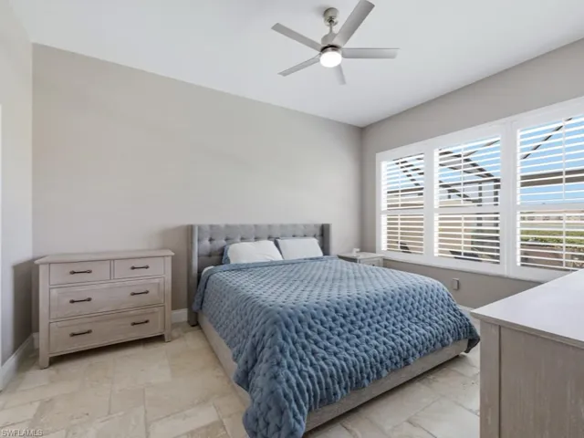 Bedroom featuring stone tile floors and a ceiling fan