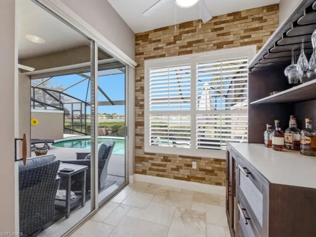 Dining area featuring a sunroom, a ceiling fan, and stone tile floors