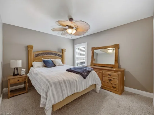 Bedroom with a ceiling fan and light colored carpet
