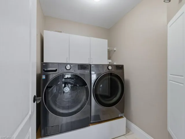 Laundry area featuring cabinet space and washing machine and clothes dryer