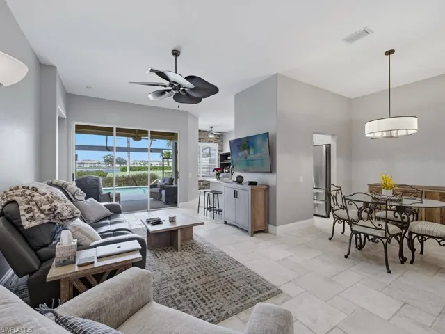 Living room featuring ceiling fan and stone tile flooring
