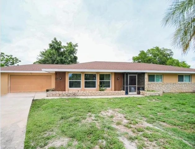 Ranch-style home with a garage and a front yard