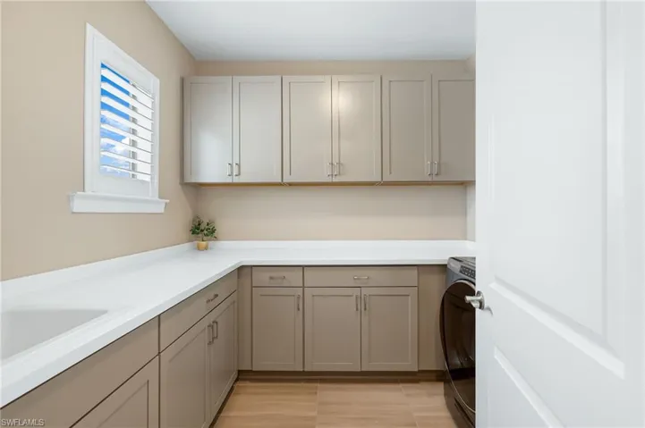 Clothes washing area with washer / clothes dryer and cabinets