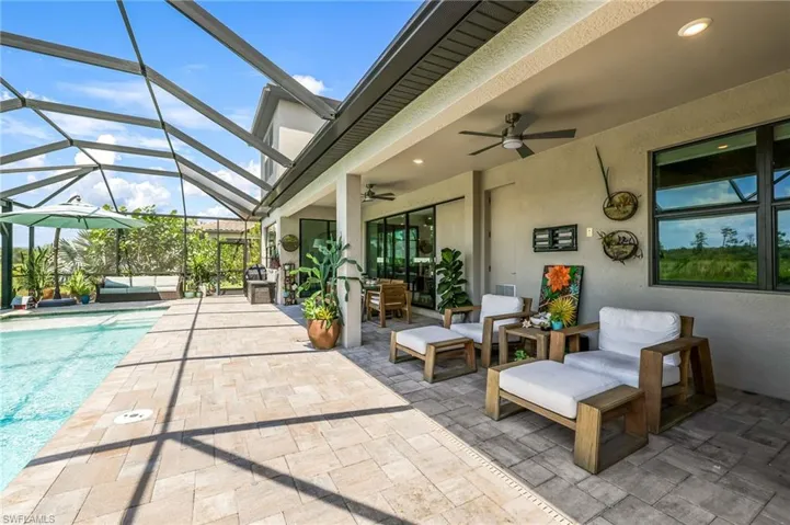 View of patio with ceiling fan and a lanai