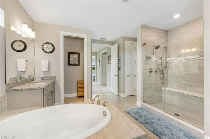 Bathroom featuring plus walk in shower and vanity