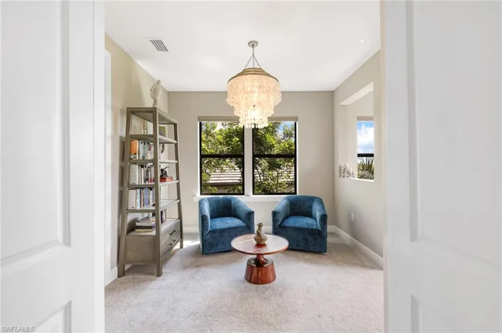 Living area featuring a chandelier and light colored carpet