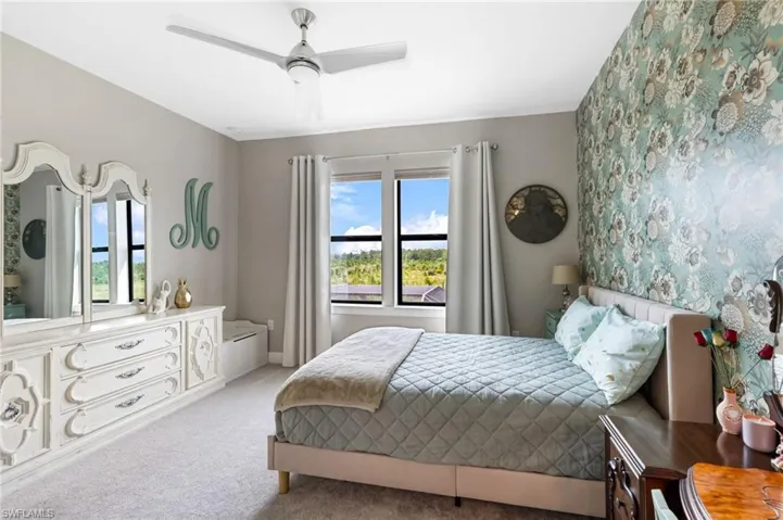 Carpeted bedroom featuring ceiling fan