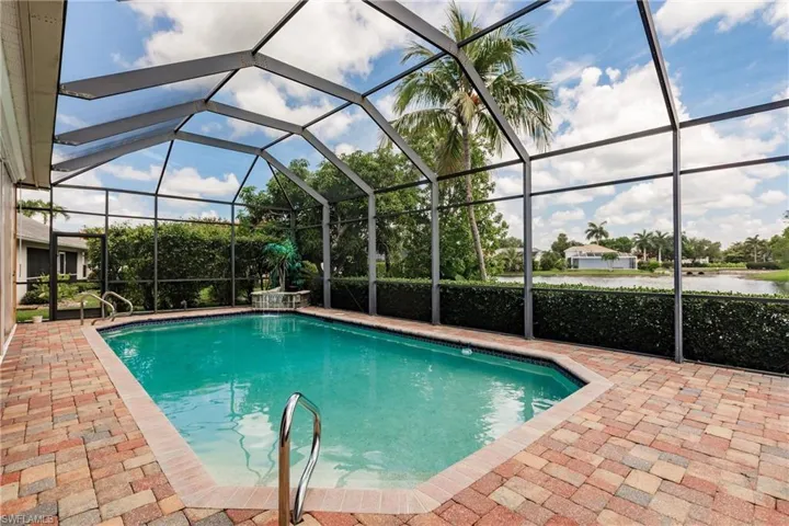 Outdoor pool with a patio area, a water view, and a lanai