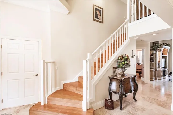Staircase with a towering ceiling and crown molding