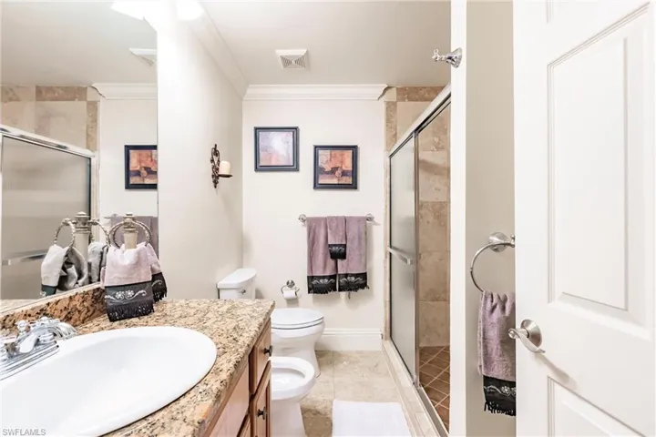 Bathroom with vanity, a stall shower, ornamental molding, and tile patterned flooring