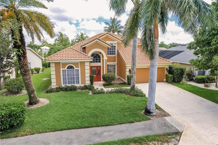 Mediterranean / spanish home with a tiled roof, decorative driveway, stucco siding, a garage, and french doors
