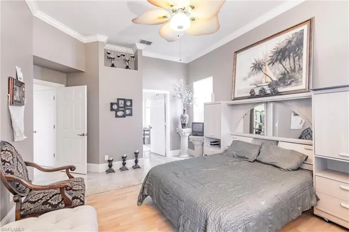 Bedroom with ornamental molding, ceiling fan, and light wood finished floors