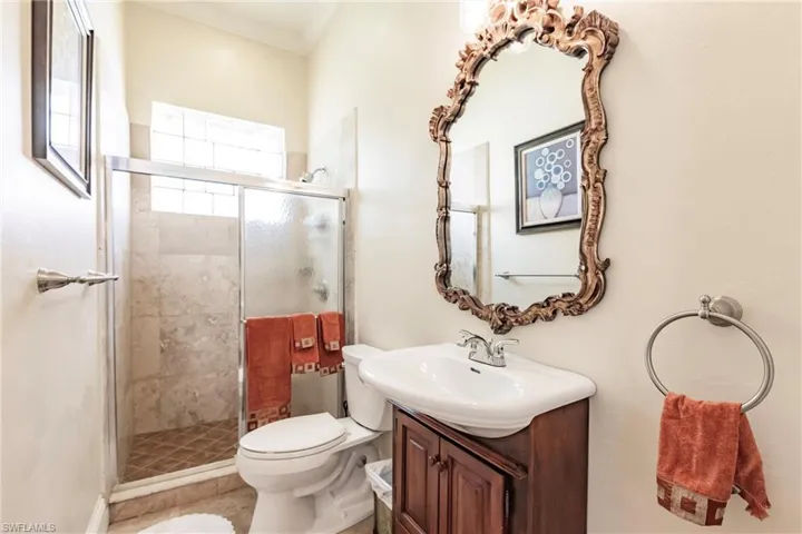 Bathroom featuring vanity, a stall shower, and crown molding