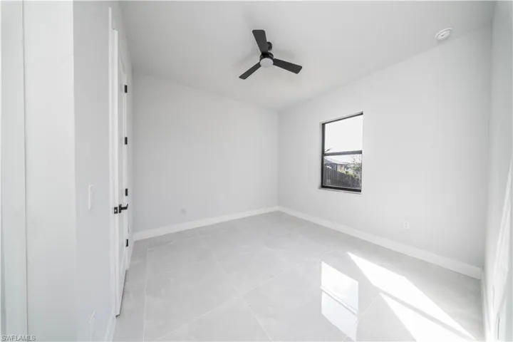Spare room featuring ceiling fan and light tile patterned floors