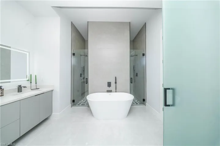 Bathroom featuring a soaking tub, a stall shower, vanity, and light tile patterned floors
