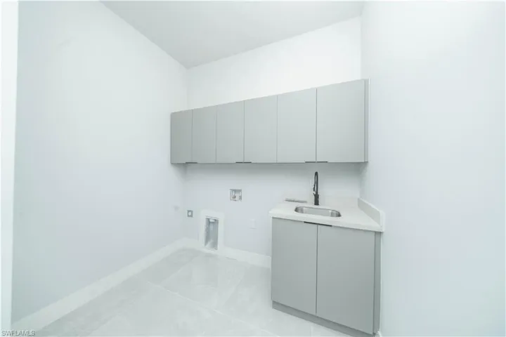 Laundry room featuring gas dryer hookup, hookup for a washing machine, cabinet space, and light tile patterned flooring