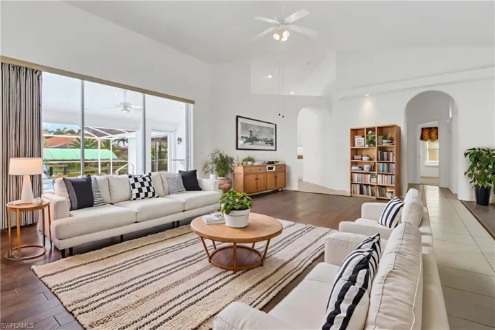 Living room featuring dark hardwood / wood-style floors, ceiling fan, and high vaulted ceiling