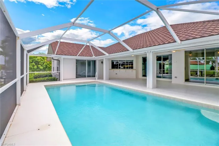 View of swimming pool featuring a patio area and glass enclosure
