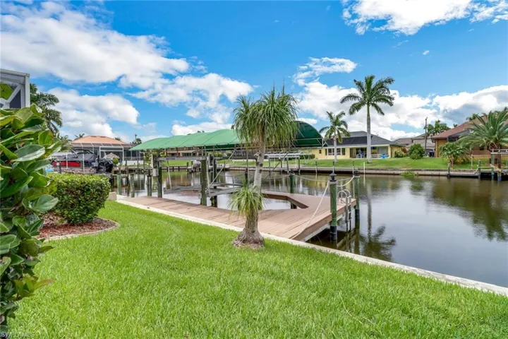 View of dock featuring a water view and a lawn