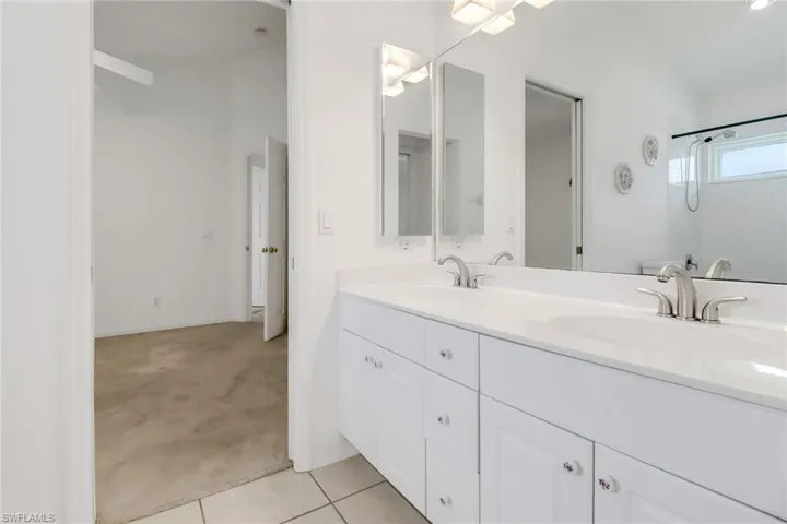 Bathroom with tile patterned flooring and dual bowl vanity