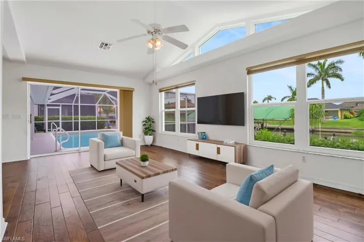 Family room featuring wood-type flooring, ceiling fan, and high vaulted ceiling